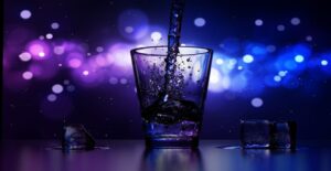 A photo of water being spilled into a glass. The background is blue and purple, and there are a few ice cubes beside the glass. 
