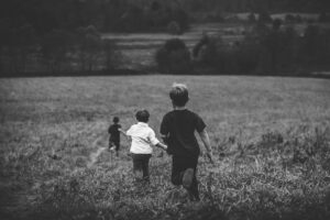 Three boys playing in the field. 