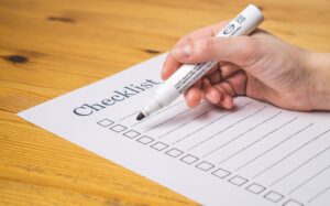 Hand holding a marker over an empty Checklist sheet.