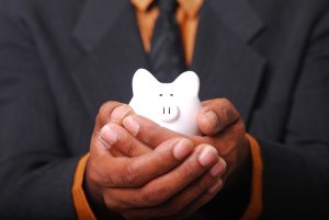 There will be no need to reach out for your piggy bank upon receiving our movers East Rutherford NJ moving quote. A man holding a piggy bank.