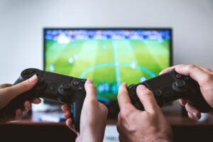 two people playing games and holding joysticks