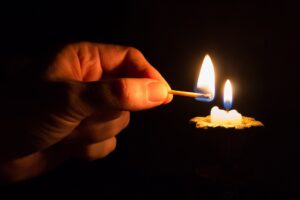 person lighting a candle 