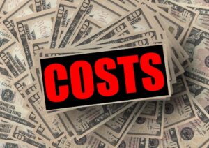 Costs sign over dollar bills.