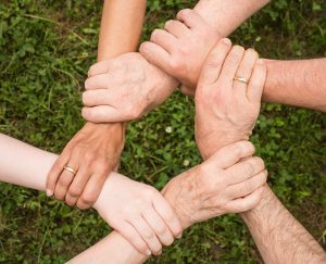 We care for other people and always search for the best ways to help those in need. People holding their hands as a sign of a team spirit.