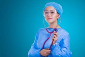 A nurse standing in front of a blue surface.