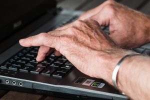Do research before you decide which moving company you will hire Senior typing on lap top