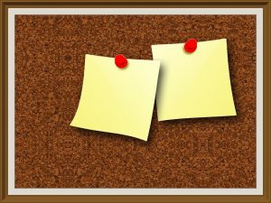 One of the most useful low-budget storage hacks is a cork board where you can keep jewelry. A cork board with two post it notes.