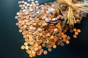 Stay away from low-ball moving estimates! Coins spilling out of a jar.