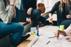 Have your friend bring you in on the details of the move – it’s of utmost importance. A group of people talking about how to help your friends relocate.