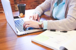 person on laptop planning to prevent losses when moving offices