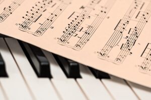 piano keyboard and sheet music over it