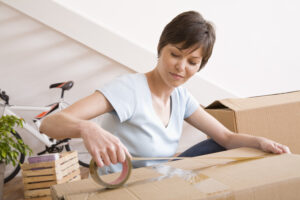 Woman taping moving boxes