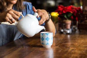 Plenty of fluids are a must! Person pouring tea.