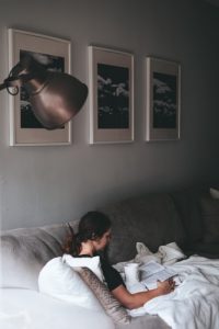 Take the time to rest even while moving. A person resting on the sofa in the middle of moving while sick.