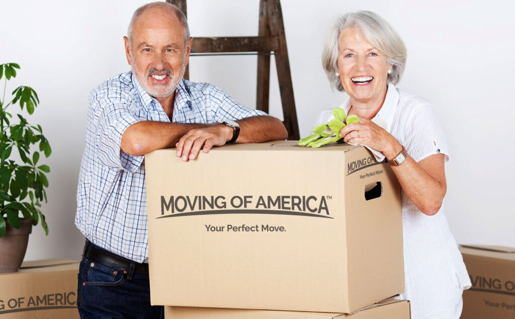 Senior Citizens standing with the Moving of America boxes with a smile on their face.