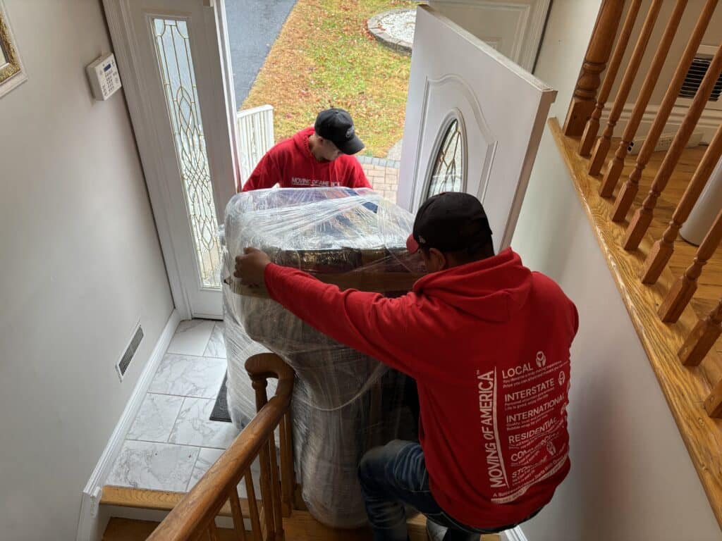 Two Moving of America professionals helping someone move